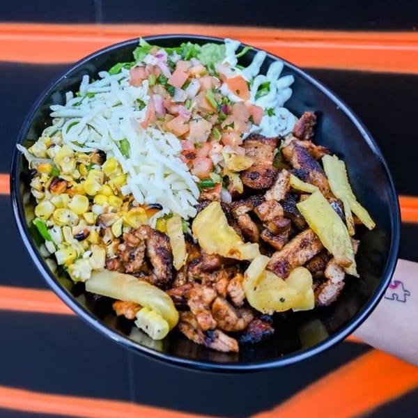 A Tacos Number Juan Mexican bowl with grilled chicken, corn, cheese, pico de gallo, and crema.